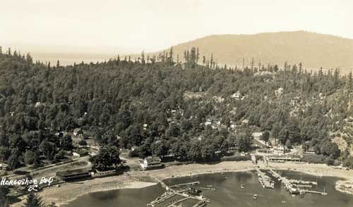 A postcard containing an aerial photograph of Horseshoe Bay showing docks and the Horseshoe Bay Hotel. Image Courtesy: West Vancouver Archives