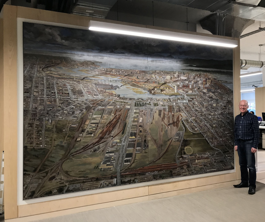 Tom Carter with his huge 2018 painting set in the 1940s looking west across False Creek and Vancouver, a commission for Chip Wilson’s corporate office. PHOTO BY CHRISTIAN NICOLA
